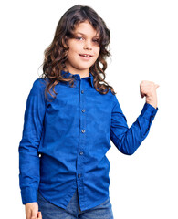 Cute child with long hair wearing casual clothes smiling with happy face looking and pointing to the side with thumb up.
