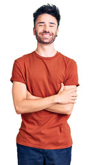 Fototapeta premium Young hispanic man wearing casual clothes happy face smiling with crossed arms looking at the camera. positive person.