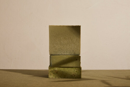 Cannabidiol CBD infused soap bars, organic handmade vegan cannabis skincare cosmetic hemp product with medicinal properties. Green bar with dried leaves and texture. Sun light, shadows and copy space