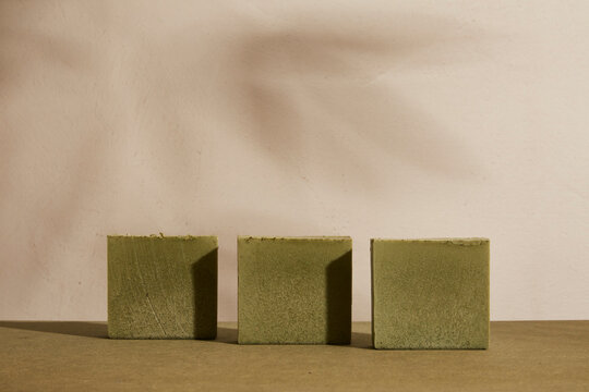 Cannabidiol CBD infused soap bars, organic handmade vegan cannabis skincare cosmetic hemp product with medicinal properties. Green bar with dried leaves and texture. Sun light, shadows and copy space