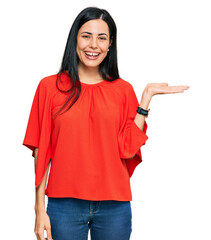 Beautiful young woman wearing casual clothes smiling cheerful presenting and pointing with palm of hand looking at the camera.