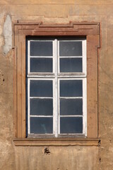 Baroque window with dirty panes and peeling paint on the dilapidated Augustinian monastery facade in Pfaffen-Schwabenheim, Germany