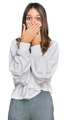 Young brunette woman wearing casual turtleneck sweater shocked covering mouth with hands for mistake. secret concept.