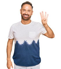 Handsome middle age man wearing casual tie dye tshirt showing and pointing up with fingers number four while smiling confident and happy.