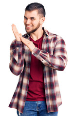 Young handsome man wearing casual shirt clapping and applauding happy and joyful, smiling proud...