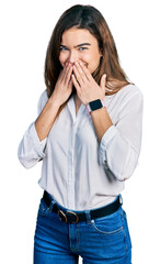 Young caucasian girl wearing casual white shirt laughing and embarrassed giggle covering mouth with hands, gossip and scandal concept