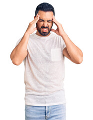 Young hispanic man wearing casual clothes with hand on head for pain in head because stress. suffering migraine.