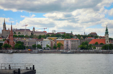 Obraz premium West bank of the Danube river, Fisherman's Bastion and blue sky with white clouds in sunny spring day in Budapest, Hungary.