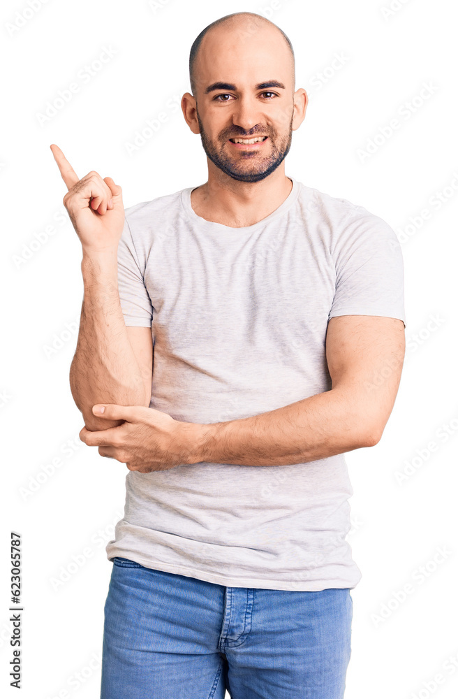 Sticker young handsome man wearing casual t shirt with a big smile on face, pointing with hand and finger to