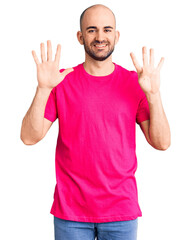 Young handsome man wearing casual t shirt showing and pointing up with fingers number nine while smiling confident and happy.