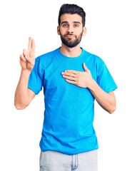 Young handsome man with beard wearing casual t-shirt smiling swearing with hand on chest and fingers up, making a loyalty promise oath