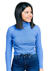 Fototapeta premium Young brunette woman with blue eyes wearing casual turtleneck sweater looking to side, relax profile pose with natural face and confident smile.