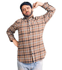 Young hispanic man wearing casual clothes stretching back, tired and relaxed, sleepy and yawning for early morning