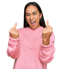 Young asian woman wearing casual winter sweater showing middle finger doing fuck you bad...