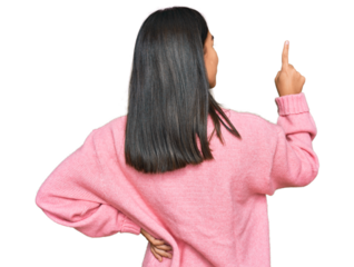 Young asian woman wearing casual winter sweater posing backwards pointing ahead with finger hand