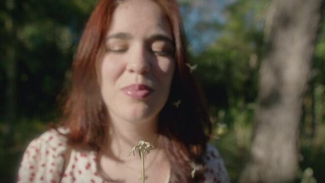 woman blows a dandelion medium shot slow motion