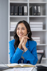 Young beautiful asian woman working in corporate office, businesswoman working in office attentively to grow and modernize start-up business, she is analyzing company's market and financial data.