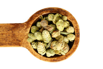 Crushed oregano spice on a wooden bamboo spoon. Healthy eating concept. Close up.