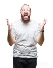 Young caucasian hipster man wearing casual t-shirt over isolated background crazy and mad shouting and yelling with aggressive expression and arms raised. Frustration concept.