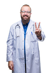 Young caucasian doctor man wearing medical white coat over isolated background smiling with happy face winking at the camera doing victory sign. Number two.