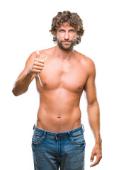 Fototapeta premium Handsome hispanic model man sexy and shirtless over isolated background doing happy thumbs up gesture with hand. Approving expression looking at the camera with showing success.