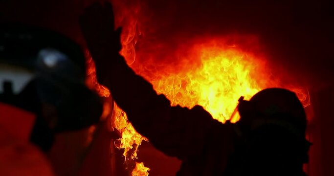 Firefighter At Work hot smoke fire emergency damage flames rescue danger burn in night scene black cinematic background 4k