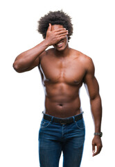 Fototapeta premium Afro american shirtless man showing nude body over isolated background smiling and laughing with hand on face covering eyes for surprise. Blind concept.