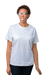 Beautiful young african american woman wearing glasses over isolated background sticking tongue out happy with funny expression. Emotion concept.