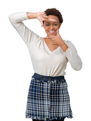 Young african american woman over isolated background smiling making frame with hands and fingers with happy face. Creativity and photography concept.