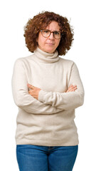Beautiful middle ager senior woman wearing turtleneck sweater and glasses over isolated background skeptic and nervous, disapproving expression on face with crossed arms. Negative person.