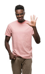 Young african american man wearing pink t-shirt showing and pointing up with fingers number five while smiling confident and happy.