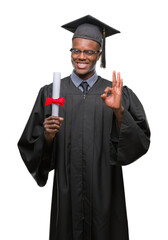 Young graduated african american man holding degree over isolated background doing ok sign with...