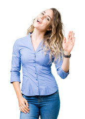 Beautiful young blonde business woman over isolated background Waiving saying hello happy and smiling, friendly welcome gesture