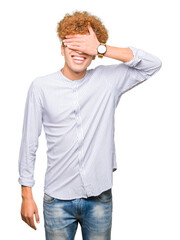 Young handsome business man with afro hair wearing elegant shirt smiling and laughing with hand on face covering eyes for surprise. Blind concept.