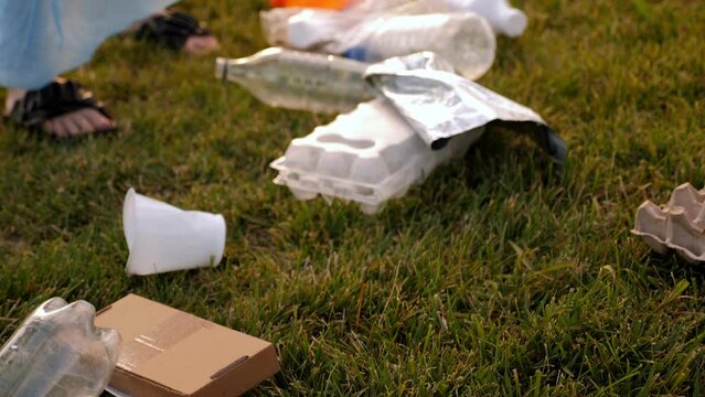 Close-up of a garbage collection tongs with a plastic bottle in the city. The concept of garbage collection and environmental protection.