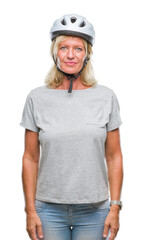 Middle age caucasian cyclist woman wearing safety helmet over isolated background with serious expression on face. Simple and natural looking at the camera.