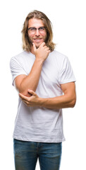 Young handsome man with long hair wearing glasses over isolated background looking confident at the camera with smile with crossed arms and hand raised on chin. Thinking positive.