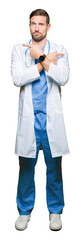 Handsome doctor man wearing medical uniform over isolated background Pointing to both sides with fingers, different direction disagree