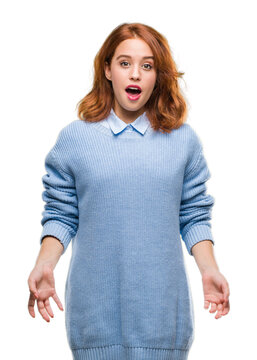 Young beautiful woman over isolated background wearing winter sweater afraid and shocked with surprise expression, fear and excited face.