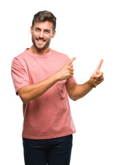 Young handsome man over isolated background smiling and looking at the camera pointing with two hands and fingers to the side.