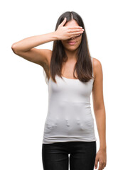 Fototapeta premium Young beautiful hispanic wearing sunglasses smiling and laughing with hand on face covering eyes for surprise. Blind concept.