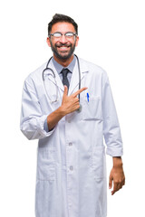 Adult hispanic doctor man over isolated background cheerful with a smile of face pointing with hand and finger up to the side with happy and natural expression on face looking at the camera.