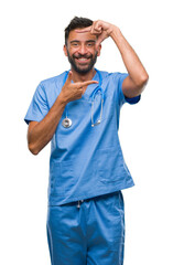 Adult hispanic doctor or surgeon man over isolated background smiling making frame with hands and fingers with happy face. Creativity and photography concept.