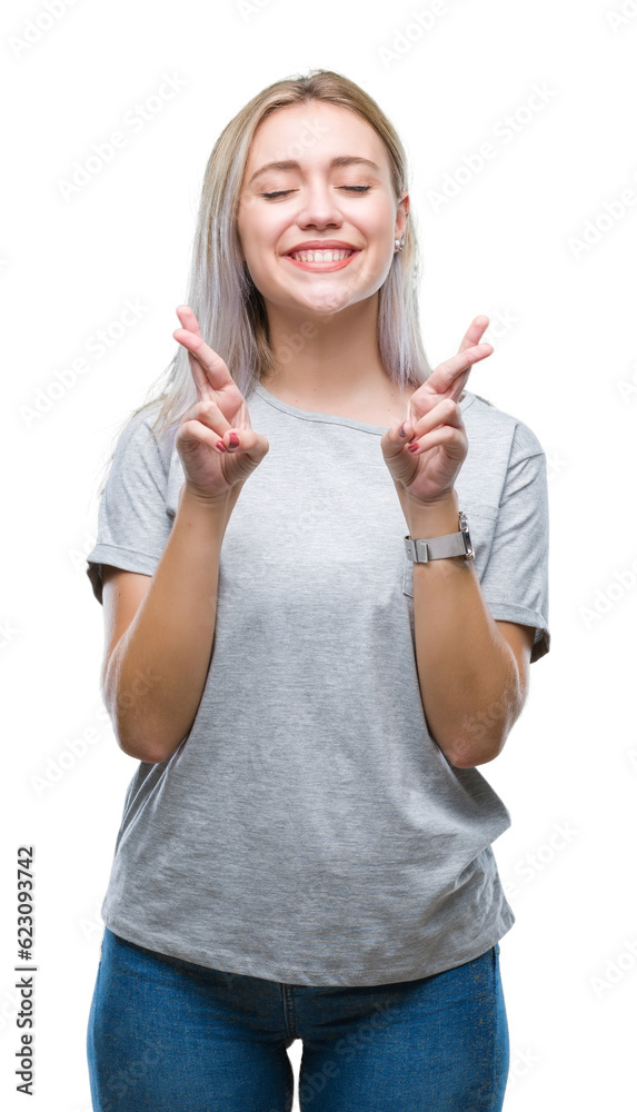 Sticker young blonde woman over isolated background smiling crossing fingers with hope and eyes closed. luck