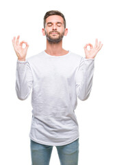 Naklejka premium Young handsome man over isolated background relax and smiling with eyes closed doing meditation gesture with fingers. Yoga concept.