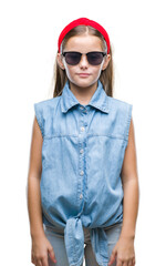 Fototapeta premium Young beautiful girl wearing sunglasses over isolated background with serious expression on face. Simple and natural looking at the camera.