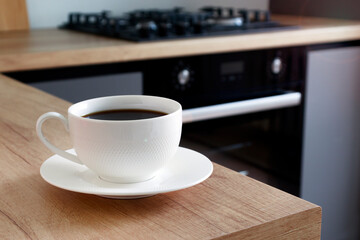 White blurred background of kitchen and white cup of coffee
