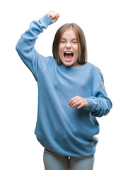 Young beautiful girl wearing winter sweater over isolated background angry and mad raising fist frustrated and furious while shouting with anger. Rage and aggressive concept.