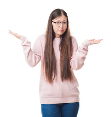 Young Chinese woman over isolated background wearing glasses clueless and confused expression with...