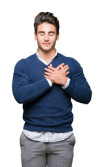 Young handsome business man over isolated background smiling with hands on chest with closed eyes and grateful gesture on face. Health concept.